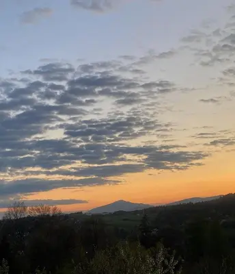 a sunset view of the mountains and trees at Domek Leniuchowo in Rabka