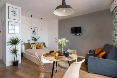 a living room with a bed and a table and chairs at Tukan Old Town in Kraków