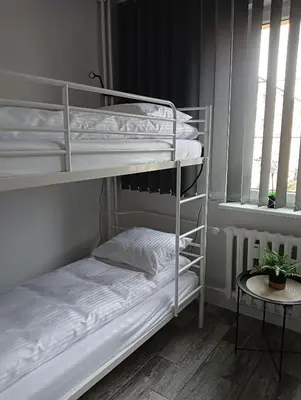 a room with two bunk beds and a table at Apartamenty Oświęcim klimatyzacja air-conditioned in Oświęcim