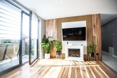 a living room with a fireplace and a tv at Wlodarska 4a Apartament Premium in Kraków