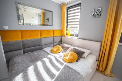 a bed with two orange pillows on it in a room at Wlodarska 4a Apartament Premium in Kraków