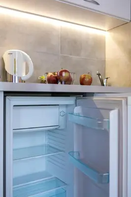 an open refrigerator with apples on top of it at Apartments Legendary Kraków in Kraków