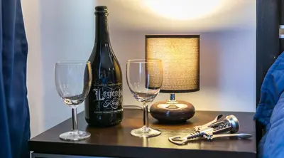 a bottle of wine and two glasses on a table at Apartments Legendary Kraków in Kraków