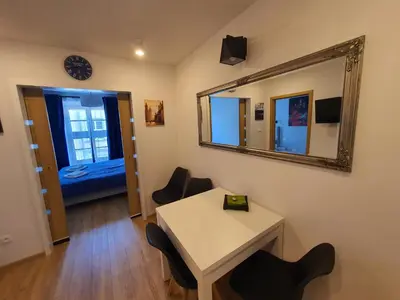 a room with a mirror and a table and chairs at Apartments Legendary Kraków in Kraków