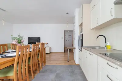 a kitchen and dining room with a table and chairs at Ruczaj Apartment Cracow Dębniki by Noclegi Renters in Kraków