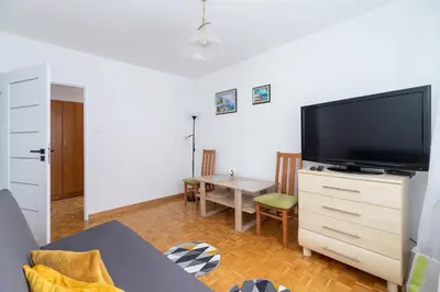 a living room with a flat screen tv on a dresser at Ruczaj Apartment Cracow Dębniki by Noclegi Renters in Kraków