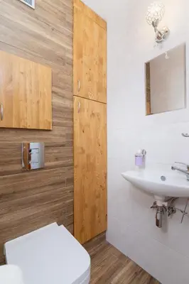 a bathroom with a white toilet and a sink at Ruczaj Apartment Cracow Dębniki by Noclegi Renters in Kraków