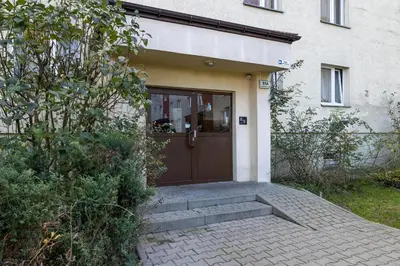 a house with a brown door and stairs in front at Ruczaj Apartment Cracow Dębniki by Noclegi Renters in Kraków