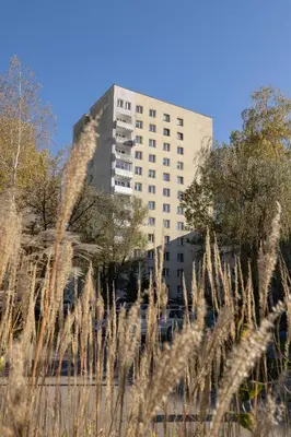 a tall building in the background with tall grass at Ruczaj Apartment Cracow Dębniki by Noclegi Renters in Kraków