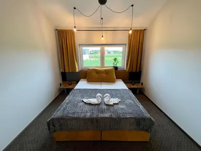 a bedroom with a bed with two shoes on it at Jaśminowa Park in Zator