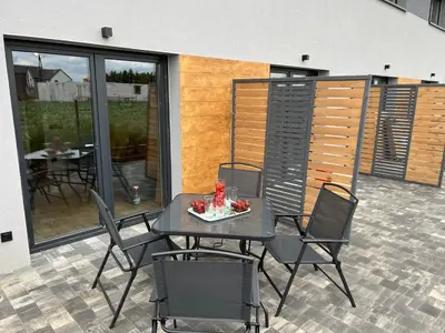 a patio with a table and chairs on a balcony at Jaśminowa Park in Zator