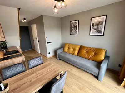 a living room with a couch and a table at Jaśminowa Park in Zator