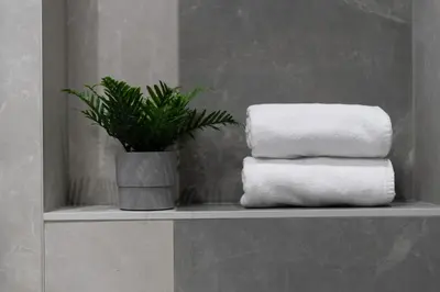 a stack of towels on a shelf with a plant at Verona House - Premium Apartment in Kraków