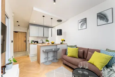 a living room with a couch and a kitchen at Verona House - Premium Apartment in Kraków