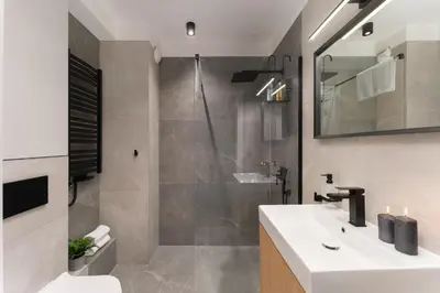 a bathroom with a white sink and a shower at Verona House - Premium Apartment in Kraków