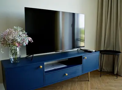 a blue dresser with a tv on top of it at Apartament Thaddeus 48 z tarasem in Zator
