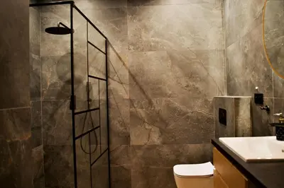 a bathroom with a shower with a toilet and a sink at Apartament Thaddeus 48 z tarasem in Zator