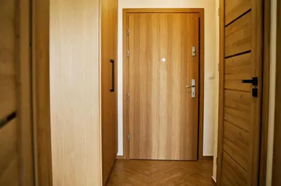 a hallway with a wooden door in a room at Apartament Thaddeus 48 z tarasem in Zator