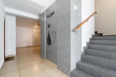 a hallway with stairs and a sign on the wall at Stawowa Apartment with Balcony & Parking Cracow by Noclegi Renters in Kraków