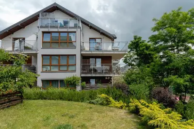 a house with a garden in front of it at Stawowa Apartment with Balcony & Parking Cracow by Noclegi Renters in Kraków