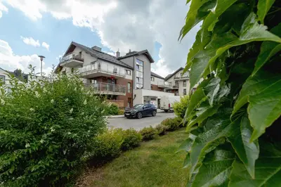 a house with a car parked in the driveway at Stawowa Apartment with Balcony & Parking Cracow by Noclegi Renters in Kraków