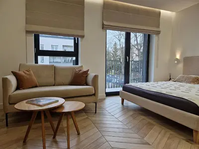 a bedroom with a bed and a couch and a table at New Funcional Easy Stay High Standard Kraków apartment free garage parking in Kraków