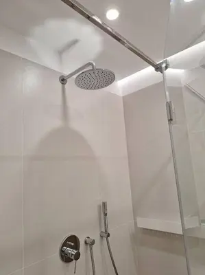 a shower with a glass door in a bathroom at New Funcional Easy Stay High Standard Kraków apartment free garage parking in Kraków