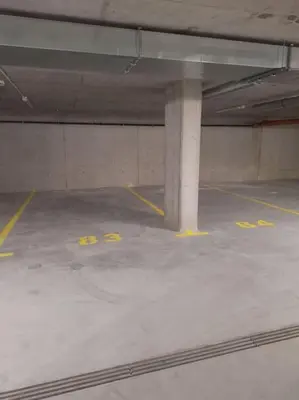 an empty parking garage with yellow numbers on the floor at New Funcional Easy Stay High Standard Kraków apartment free garage parking in Kraków