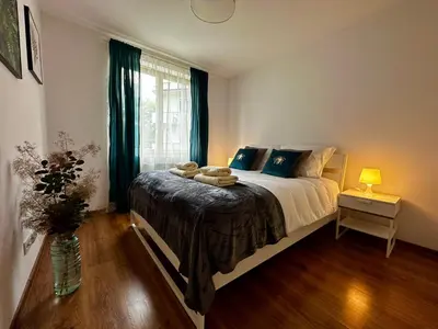 a bedroom with a bed and a vase with towels on it at Tresor Pułaskiego Apartments in Kraków