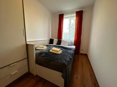 a bedroom with a bed with two towels on it at Tresor Pułaskiego Apartments in Kraków