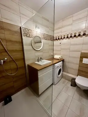 a bathroom with a sink and a washing machine at Tresor Pułaskiego Apartments in Kraków