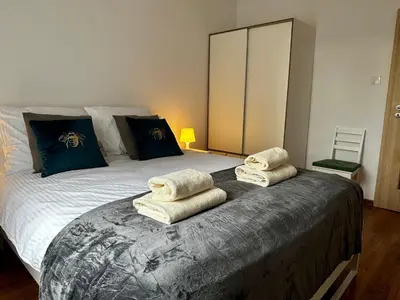 a bedroom with a bed with towels on it at Tresor Pułaskiego Apartments in Kraków