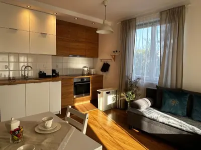 a kitchen and living room with a couch and a table at Tresor Pułaskiego Apartments in Kraków