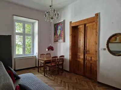 a dining room with a table and chairs and a mirror at Artapartamenty in Kraków