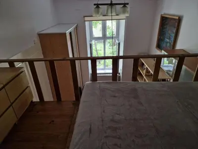 a room with a staircase with a window and a table at Artapartamenty in Kraków