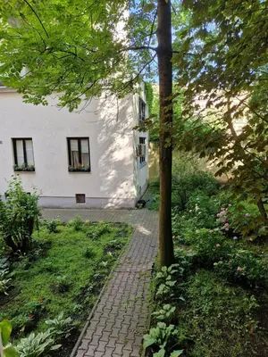 a brick path in front of a white building at Artapartamenty in Kraków