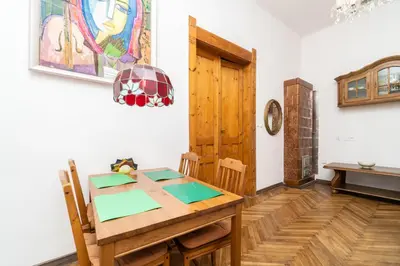 a dining room with a wooden table and a table and chairs at Artapartamenty in Kraków