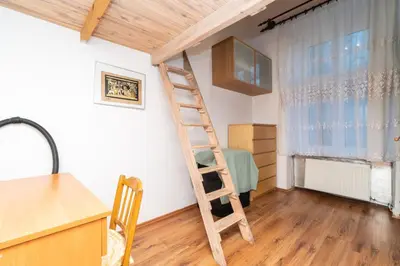 a wooden ladder in a room with a kitchen at Artapartamenty in Kraków