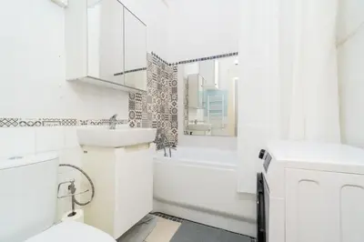 a white bathroom with a tub and a sink and a toilet at Artapartamenty in Kraków