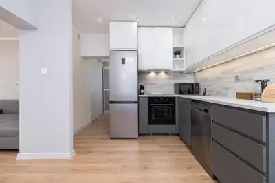 a kitchen with stainless steel appliances and white cabinets at Cosy and Comfortable Apartment in Krakow by Noclegi Renters in Kraków