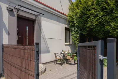 a patio with a table and chairs next to a house at Cosy and Comfortable Apartment in Krakow by Noclegi Renters in Kraków