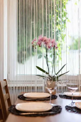 a table with plates and a vase with pink flowers at Cosy and Comfortable Apartment in Krakow by Noclegi Renters in Kraków