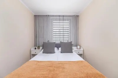 a white bedroom with a large bed and a window at Cosy and Comfortable Apartment in Krakow by Noclegi Renters in Kraków