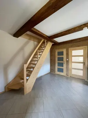 a loft with a wooden staircase in a room at PrzyStań w Gorcach in Konina