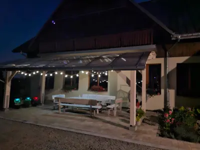 a pavilion with a picnic table and lights at night at PrzyStań w Gorcach in Konina