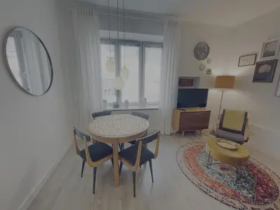 a dining room with a table and chairs and a mirror at Snow White Apartment in Kraków