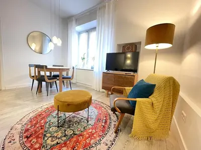 a living room with a chair and a table at Snow White Apartment in Kraków