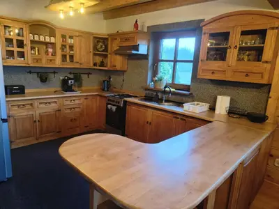 a kitchen with wooden cabinets and a wooden counter top at Zacisze na Wzgórzu in Zawoja
