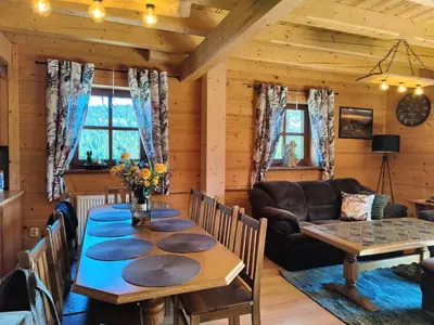 a dining room with a table and a couch at Zacisze na Wzgórzu in Zawoja