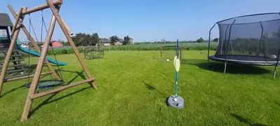 an empty playground with swings in a field of grass at Relax domki Zator in Zator